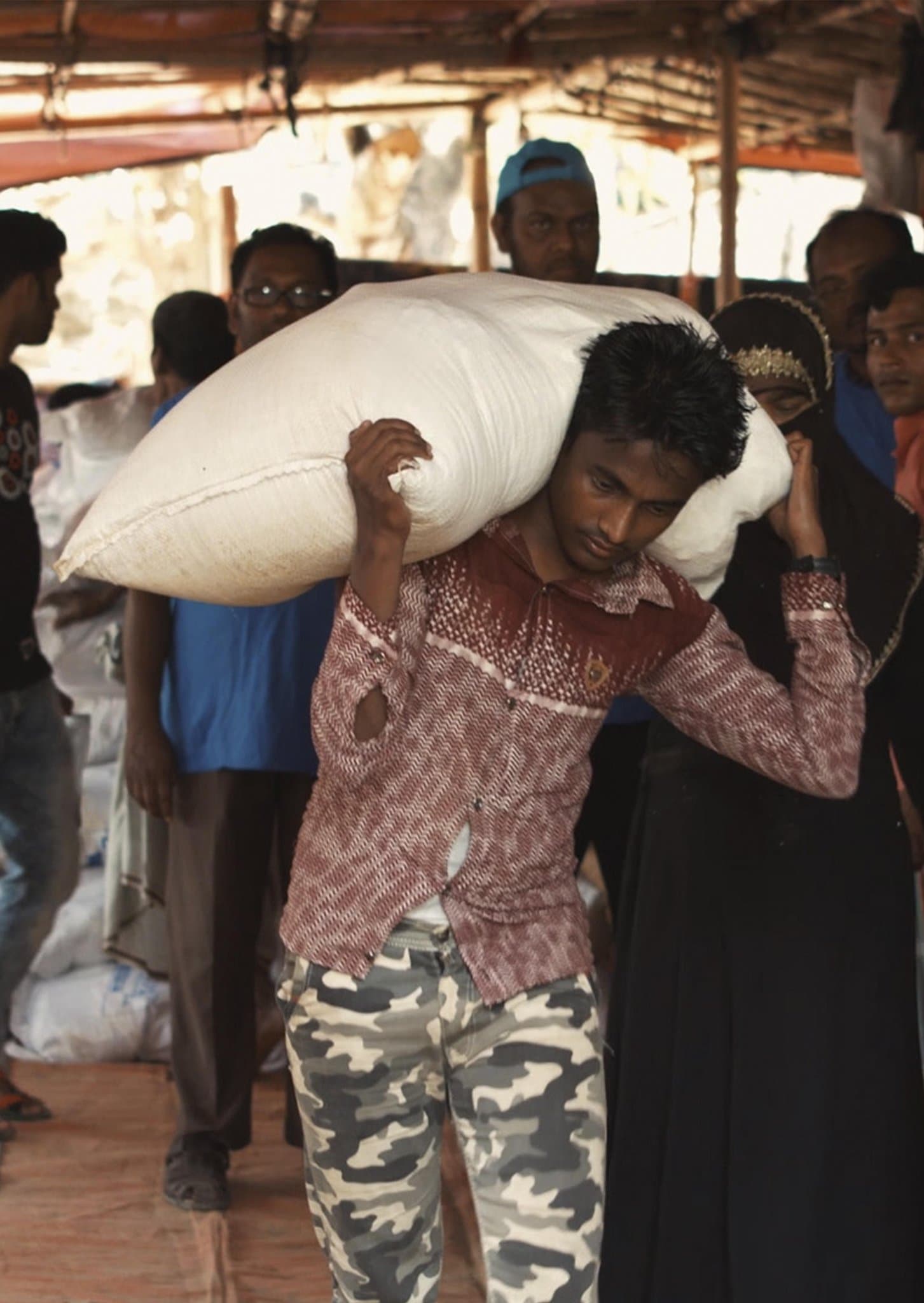 A man carrying a sack of aid on his shoulder