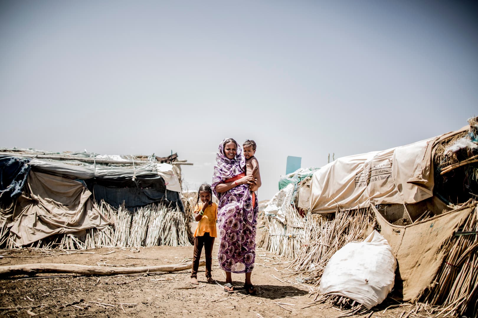 A mother and her children outside their shelter