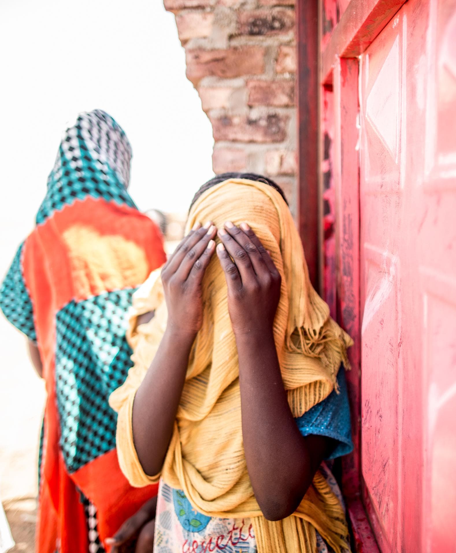 A woman covering her face with her headscarf