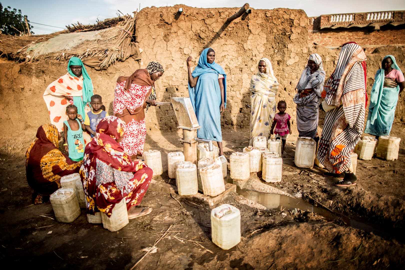 Families waiting with jerry cans at a water point