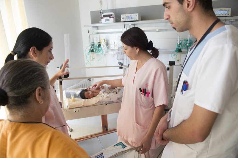 Doctors and nurses caring for a baby on a hospital ward