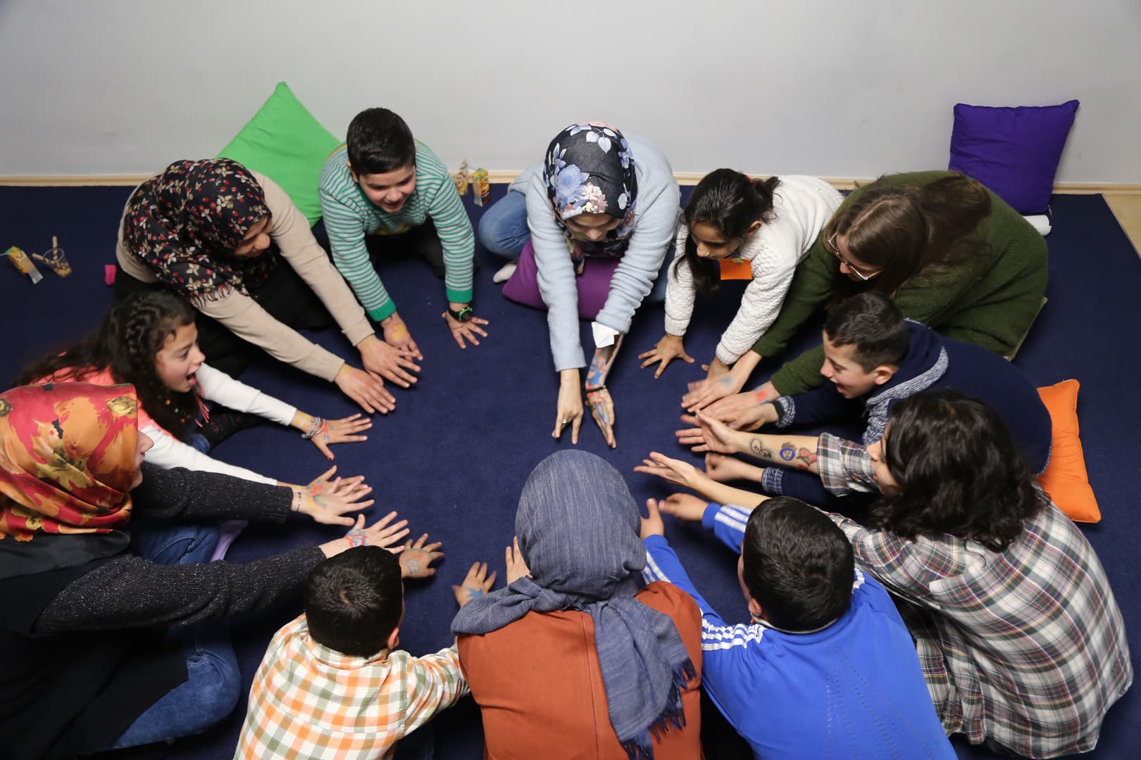 Children and teachers in a circle activity